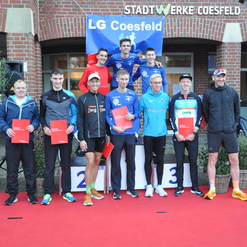 Gruppenshot von Sportlern mit Urkunden auf einem roten Teppich vor einem Gebäude der Stadtwerke Coesfeld.