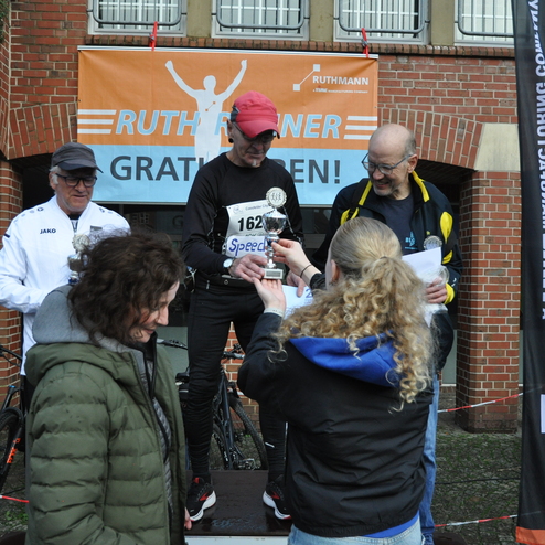 Verleihung eines Pokals an einen Teilnehmer beim Ruthmann-Lauf, umgeben von Zuschauern und Veranstaltern.