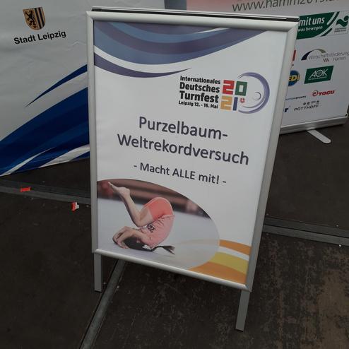 Aufsteller mit Werbung für einen Purzelbaum-Weltrekordversuch beim Internationalen Deutschen Turnfest in Leipzig.