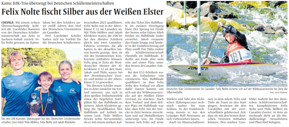 Drei Jungen in blauen T-Shirts halten einen Pokal nach einem Wettkampf im Kanu, lächelnd vor einer grünen Landschaft.