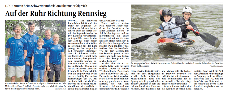 Fünf DJK-Kanuten in blauen T-Shirts stehen am Ufer des Flusses, während zwei Kanuten paddeln.