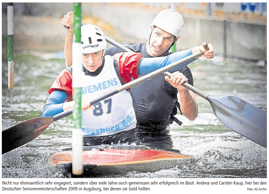 Zwei Kajakfahrer paddeln gemeinsam in einem Wasserkanal, umgeben von Wettkampfmarkierungen.