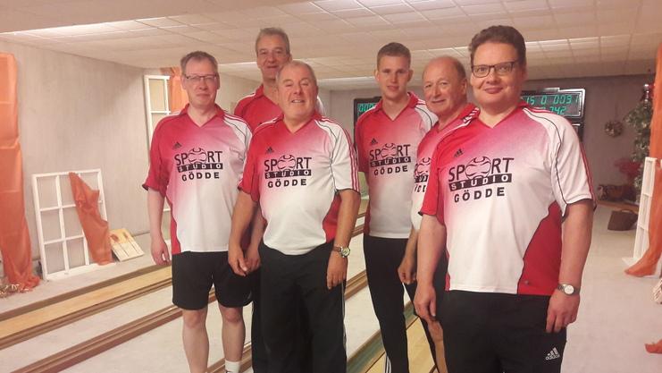 Sechs Männer in Sportkleidung stehen in einer Kegelbahn mit Holzböden und orangenen Vorhängen im Hintergrund.