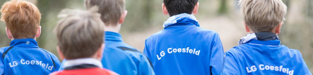 Fünf Kinder in blauen Jacken mit der Aufschrift „LG Coesfeld“ blicken in die Ferne.