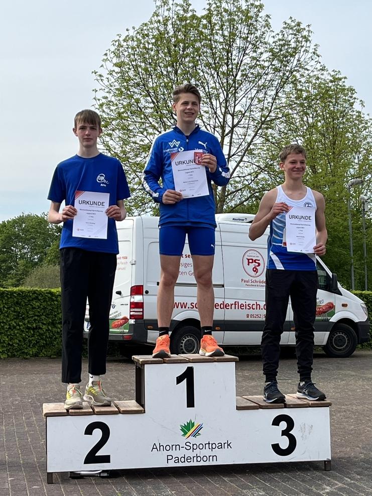 Drei Jugendliche stehen auf dem Siegertreppchen mit Urkunden beim Wettkampf im Ahorn-Sportpark Paderborn.