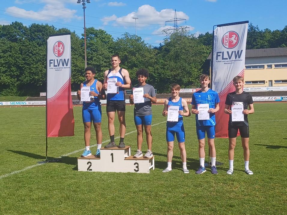 Sechs junge Athleten auf dem Siegertreppchen halten Urkunden, umgeben von grüner Landschaft und FLVW-Bannern.