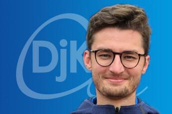 Porträt eines lächelnden Mannes mit Brille vor einem blauen Hintergrund mit dem Logo „Djk“.