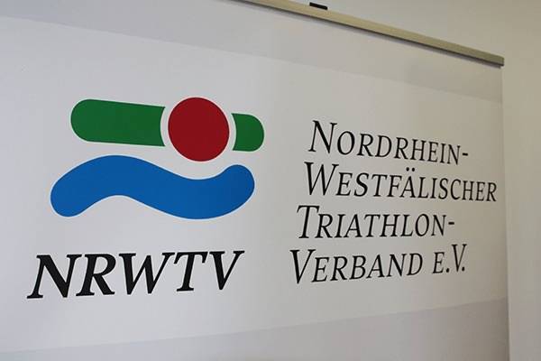 Logo des Nordrhein-Westfälischen Triathlon-Verbandes e.V. mit bunten Symbolen und der Abkürzung NRWTV.