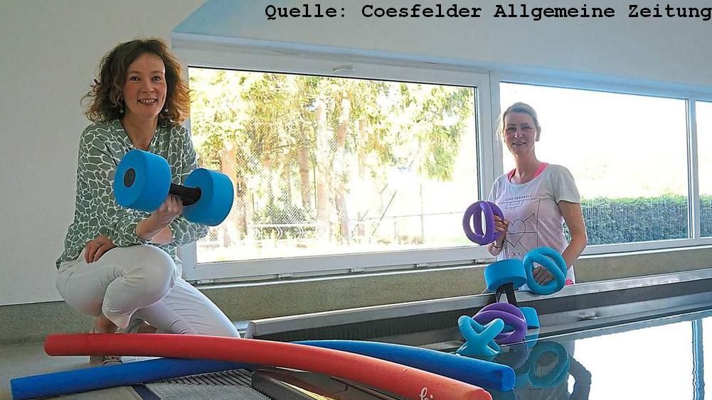 Zwei Frauen stehen in einem Raum mit Wasser und halten bunte Aquafitness-Utensilien wie Hanteln und Poolnudeln.
