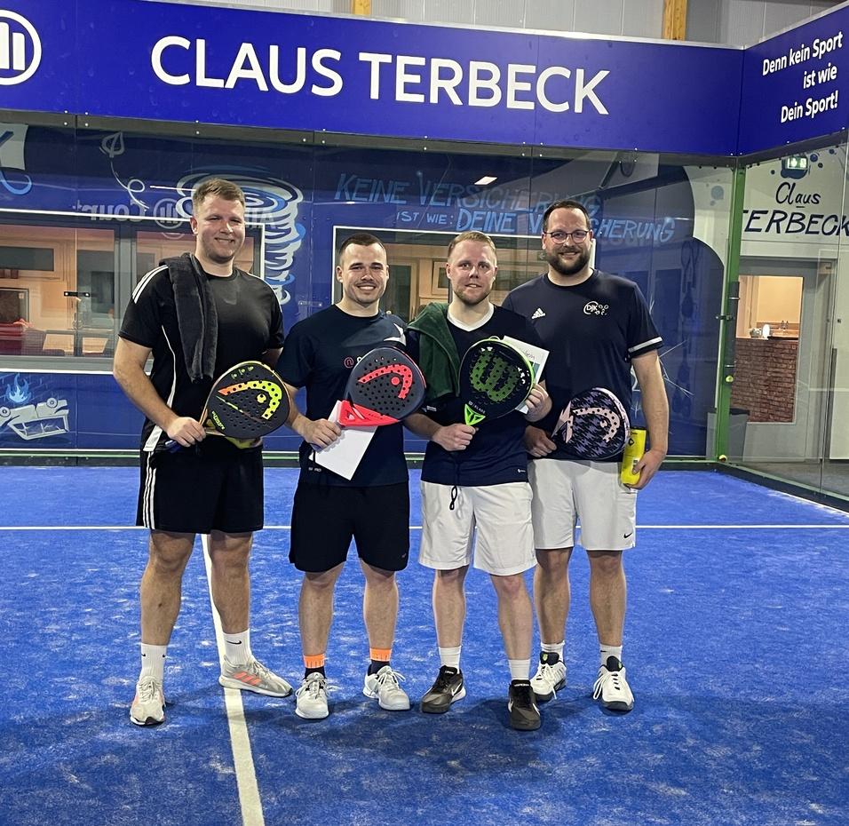 Vier Männer stehen mit Paddel-Schlägern und Urkunden auf einem blauen Padelplatz vor dem Banner „CLAUS TERBECK“.