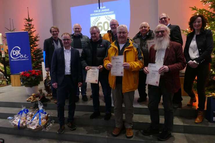 Gruppenfoto von Mitgliedern eines Vereins bei der Ehrung für 60 Jahre Zugehörigkeit, mit Urkunden und Geschenken.