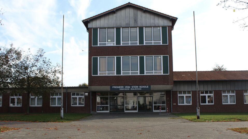 Eingang zur Freiherr-vom-Stein-Schule, moderne, zweigeschossige Backsteinbauweise, mit Fenstern und Schulplakette.