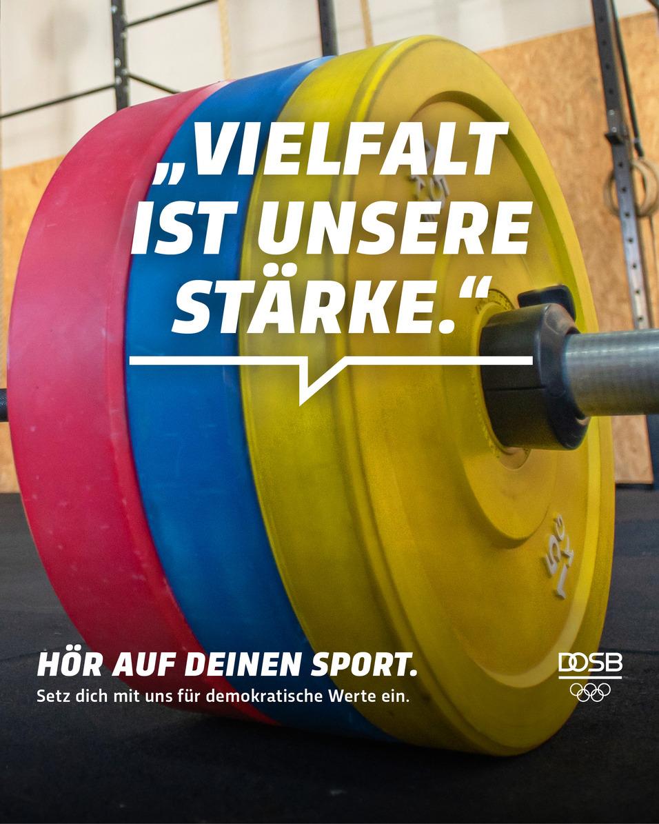 Bunte Gewichtsscheiben in Rot, Blau und Gelb auf einer Langhantel mit motivierendem Text im Vordergrund.